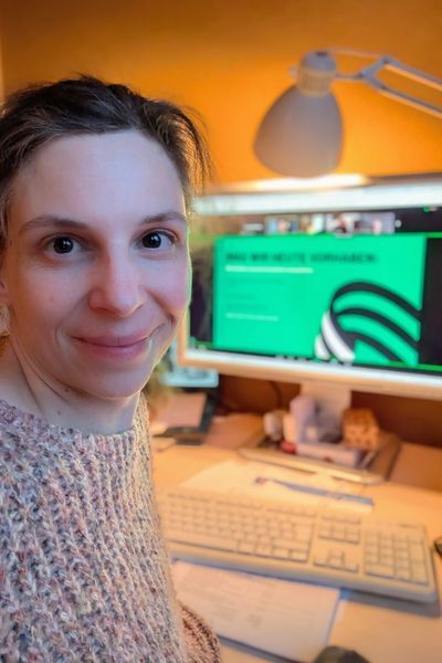 Selfie einer Katzentrainerin bei einem Workshop. Die Trainerin ist brünett mit Hazel-Augen. Sie lächelt entspannt in die Kamera.