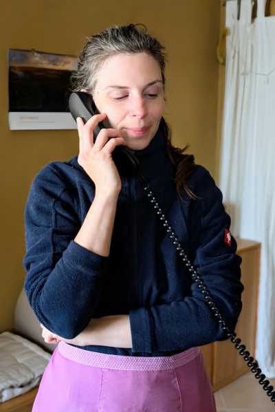 Eine Frau steht in einem Flur und telefoniert.
