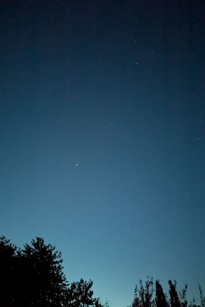 Ein Blick nach oben in den Himmel kurz vor Sonnenaufgang: tiefes Blau mit einem Hauch Türkis und vereinzelt leuchten noch ein paar Sterne.